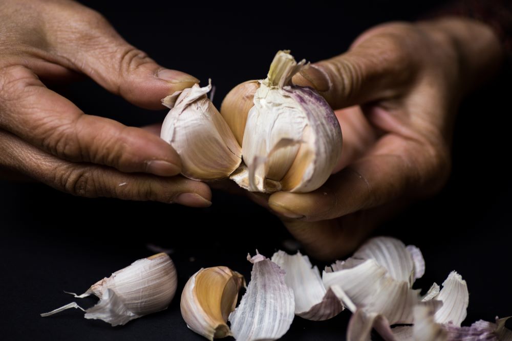 a person peeling garlic