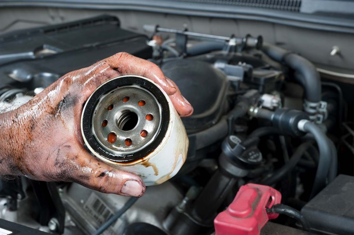 an auto mechanic changing an old oil filter