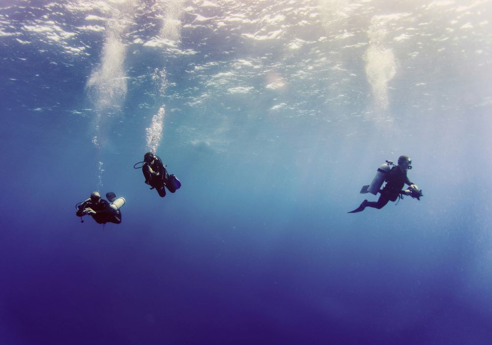 three scuba divers swimming