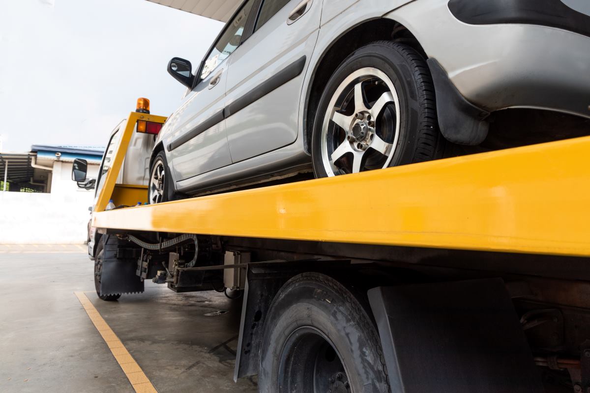 broken car on a flatbed truck