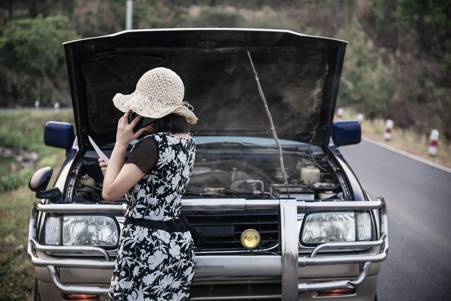 woman standing behind the car bumper