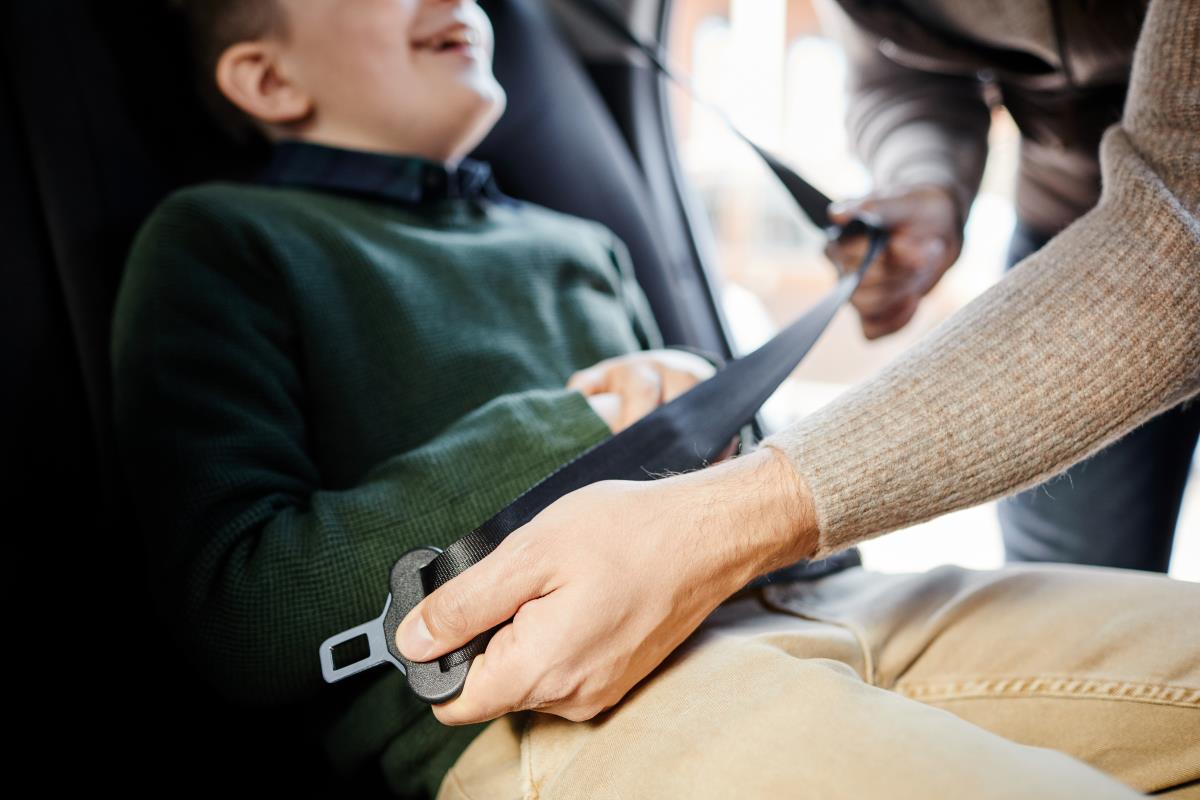 a mother wearing seat belt to her child for a safety journey