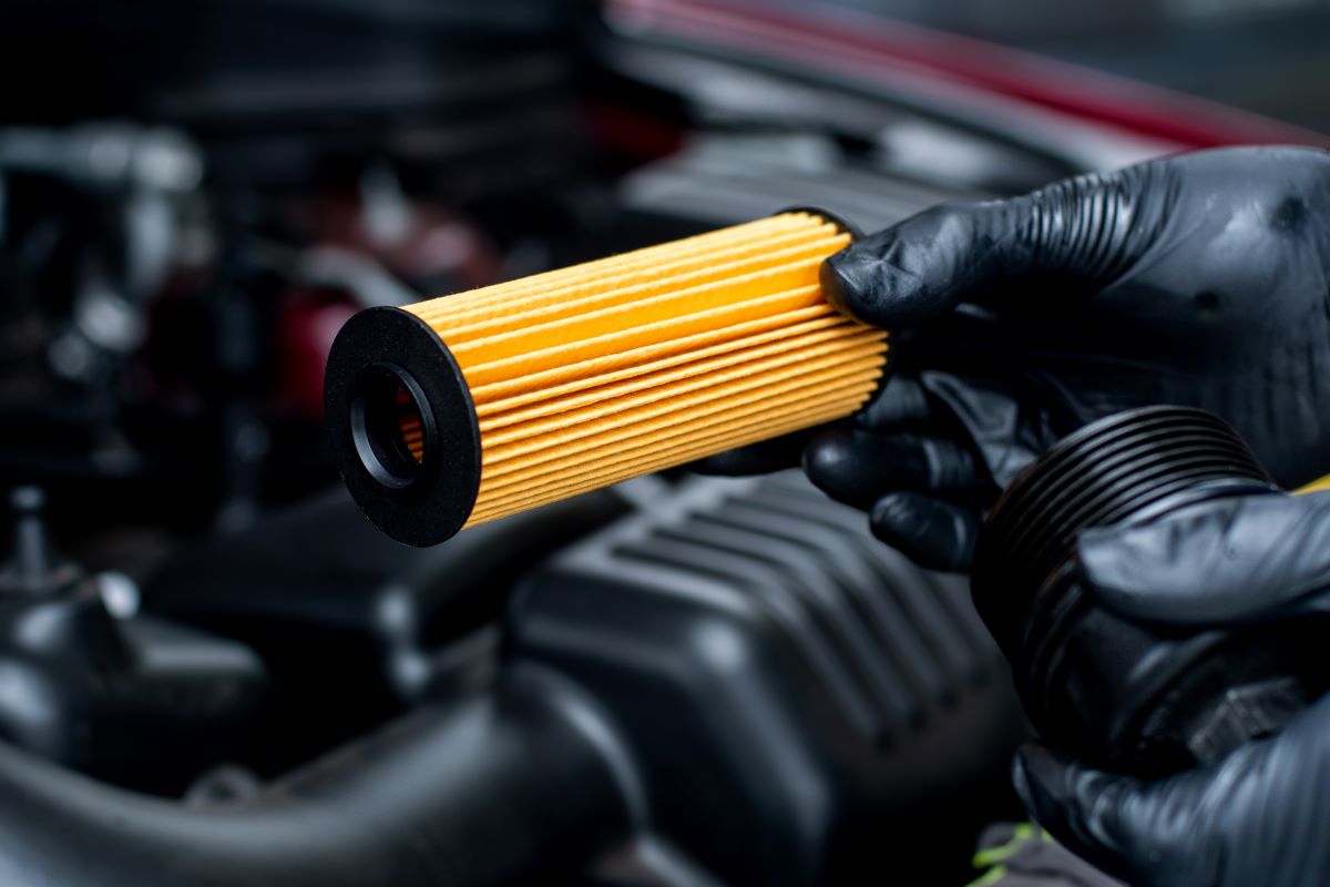 a mechanic changing oil filter at home