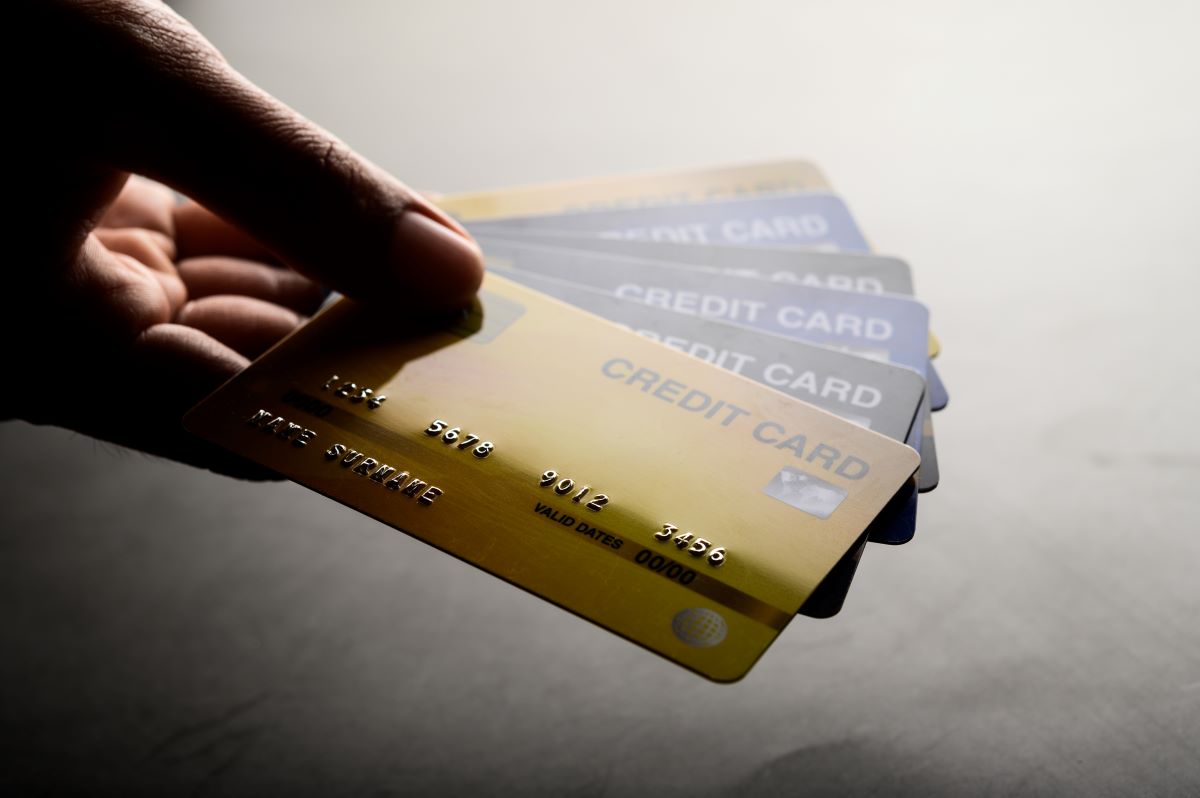 an individual holding multiple credit cards in hand