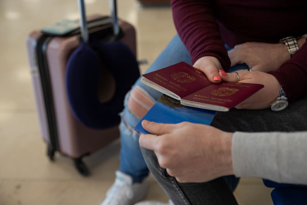 hands of a traveler couple holding passport