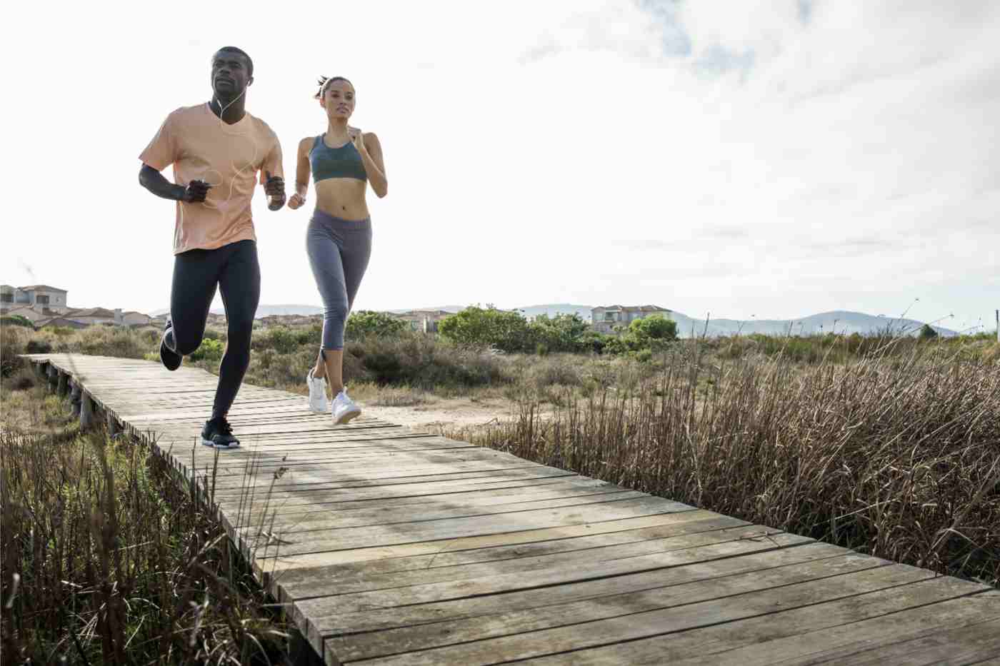 couple-jogging-on-wooden-walkway