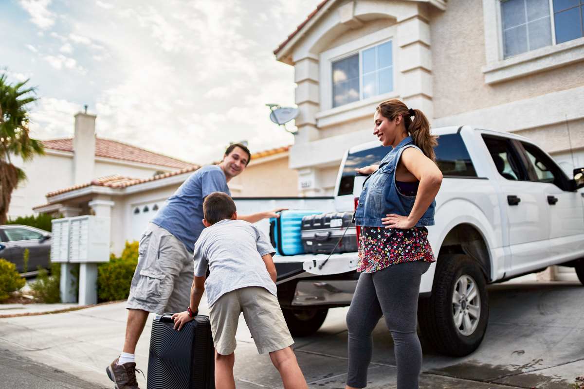 family loading luggage in pickup truck