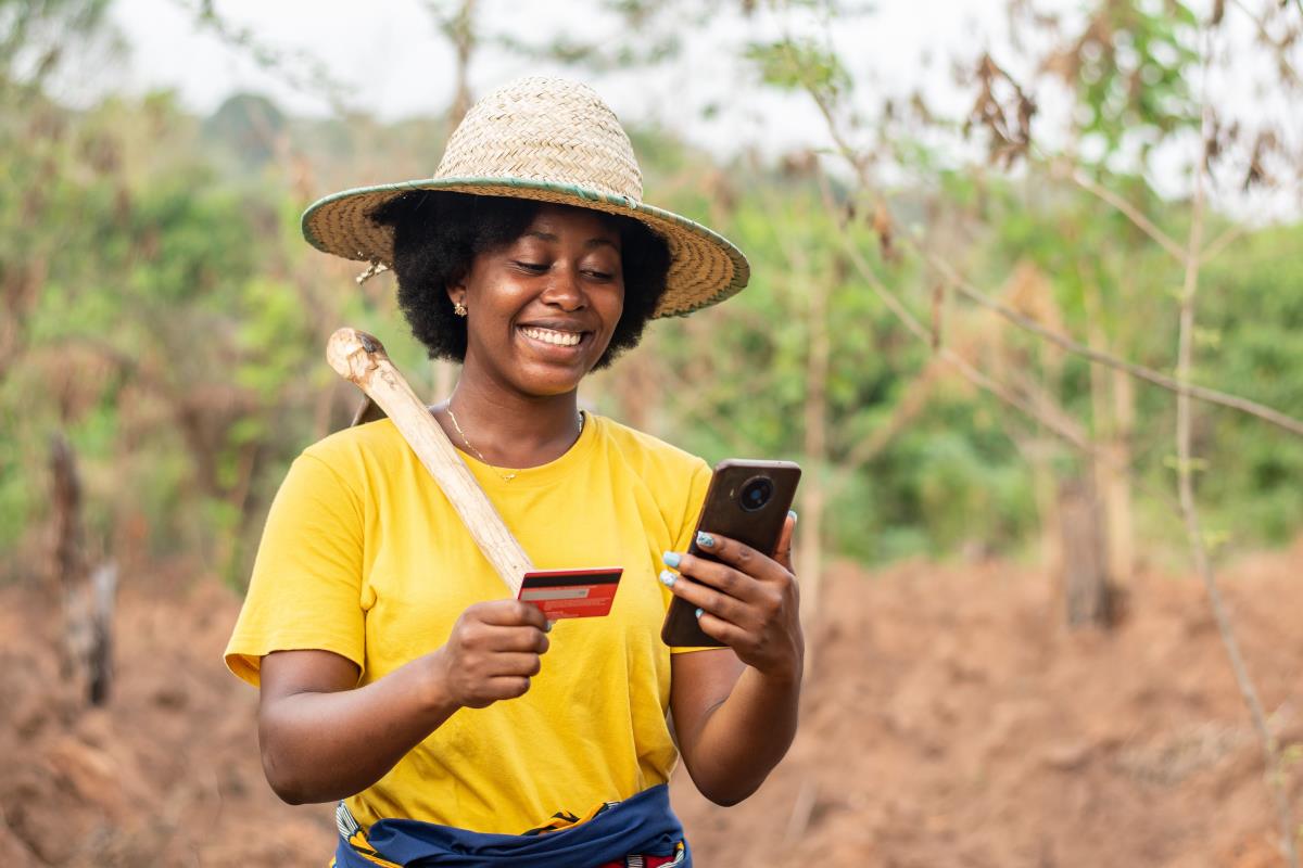 an african farmer woman opening her farmers saving account online through mobile