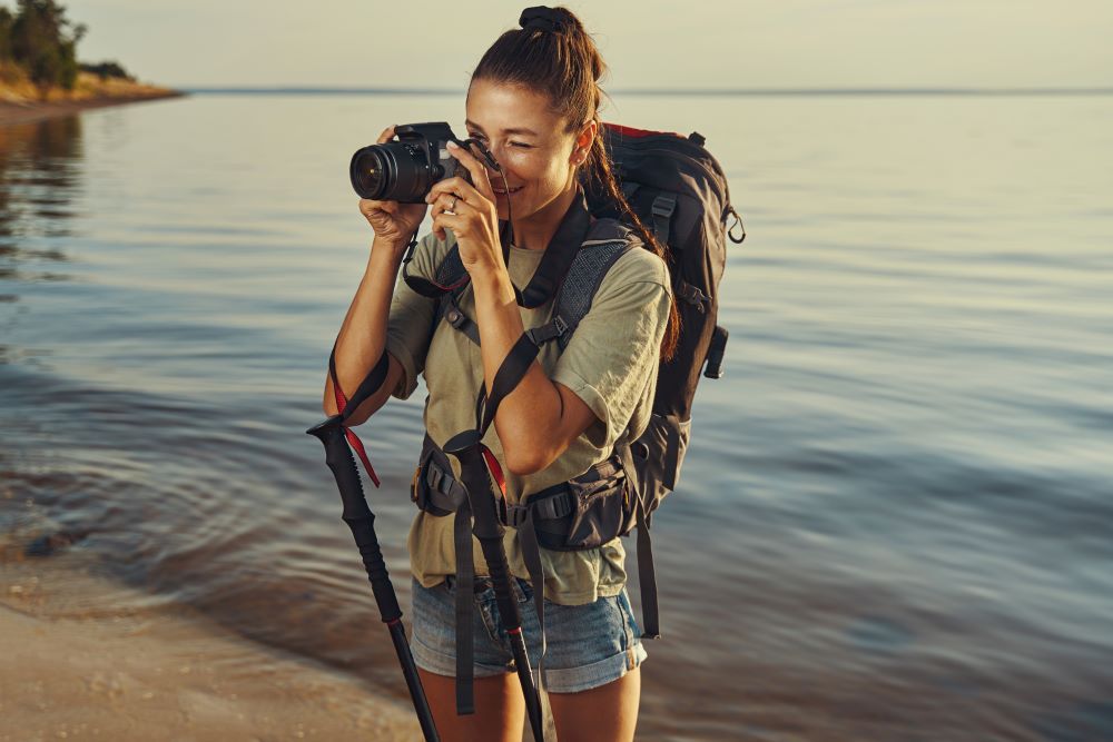 a girl taking picture on water side