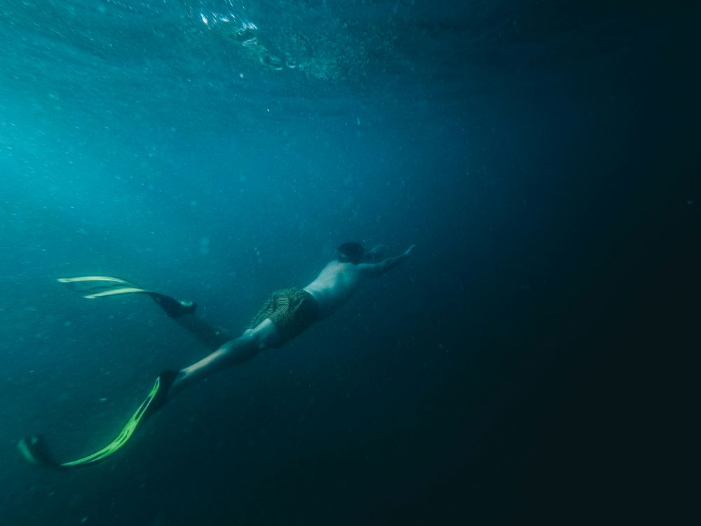 a man is swimming alone underwater