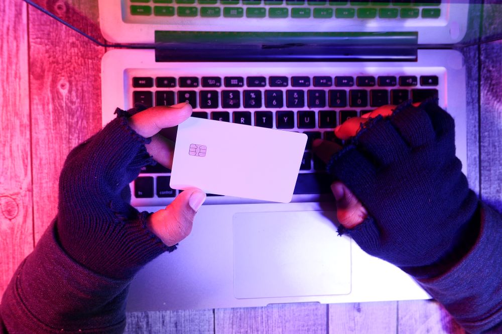 shot of hacker hands with credit card for stealing money