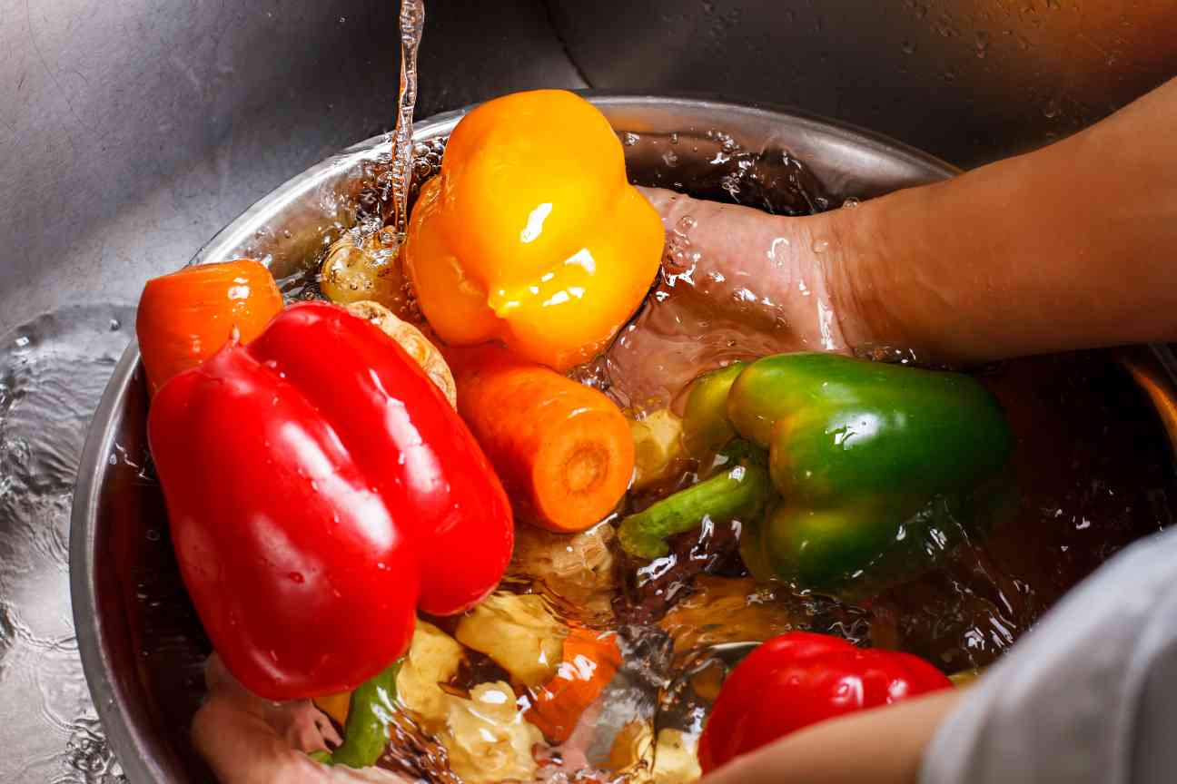 hands wash vegetables in basin