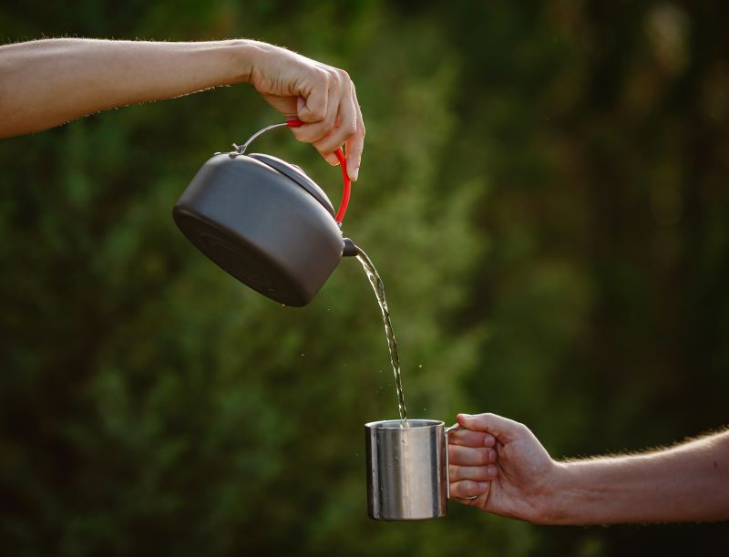 Hiker pouring hot water