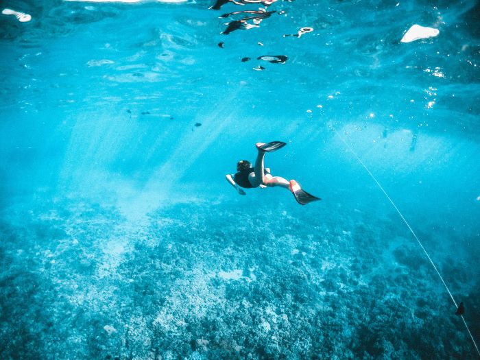 female scuba diver swimming under sea