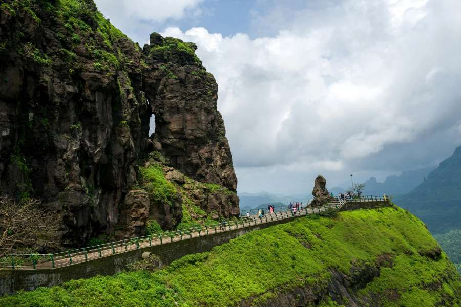 experience the amazing view of waterfall in malshej ghat surrounded by mountains and greeneries