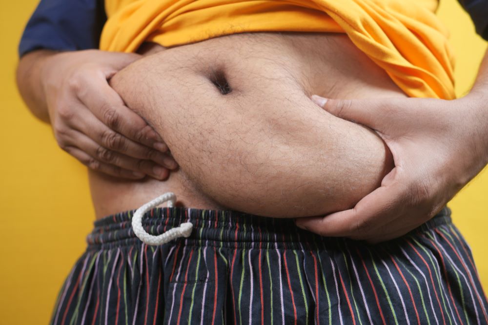 man-holding-excessive-belly-fat-overweight