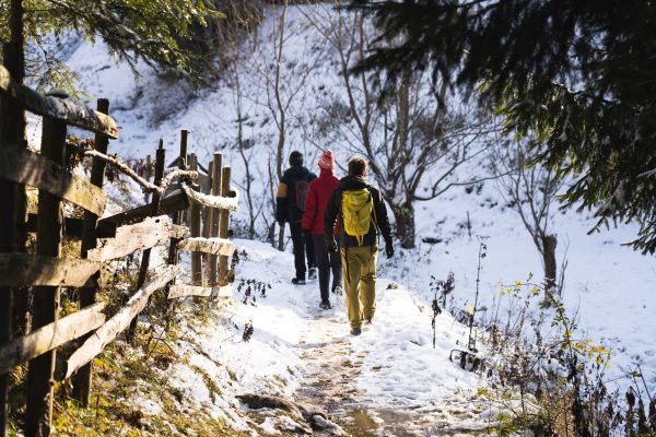 three hikers walking in snow path