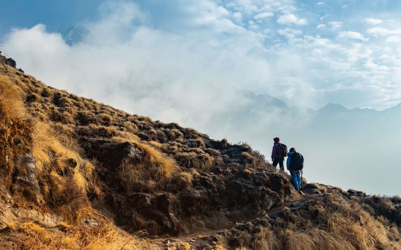 two hikers climbing hills