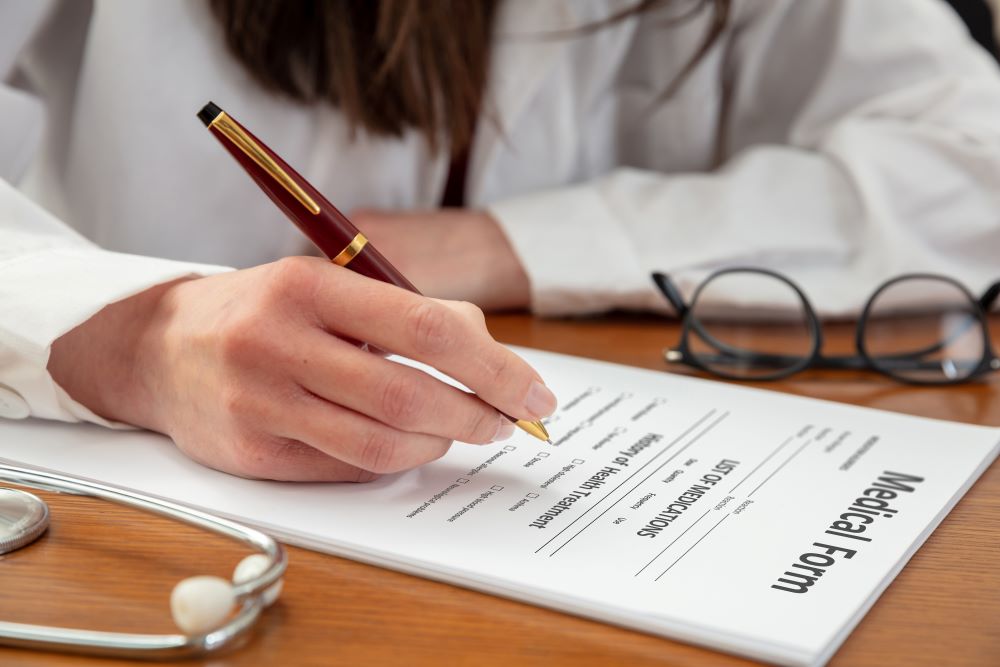 shot of a person's hand filling medical form