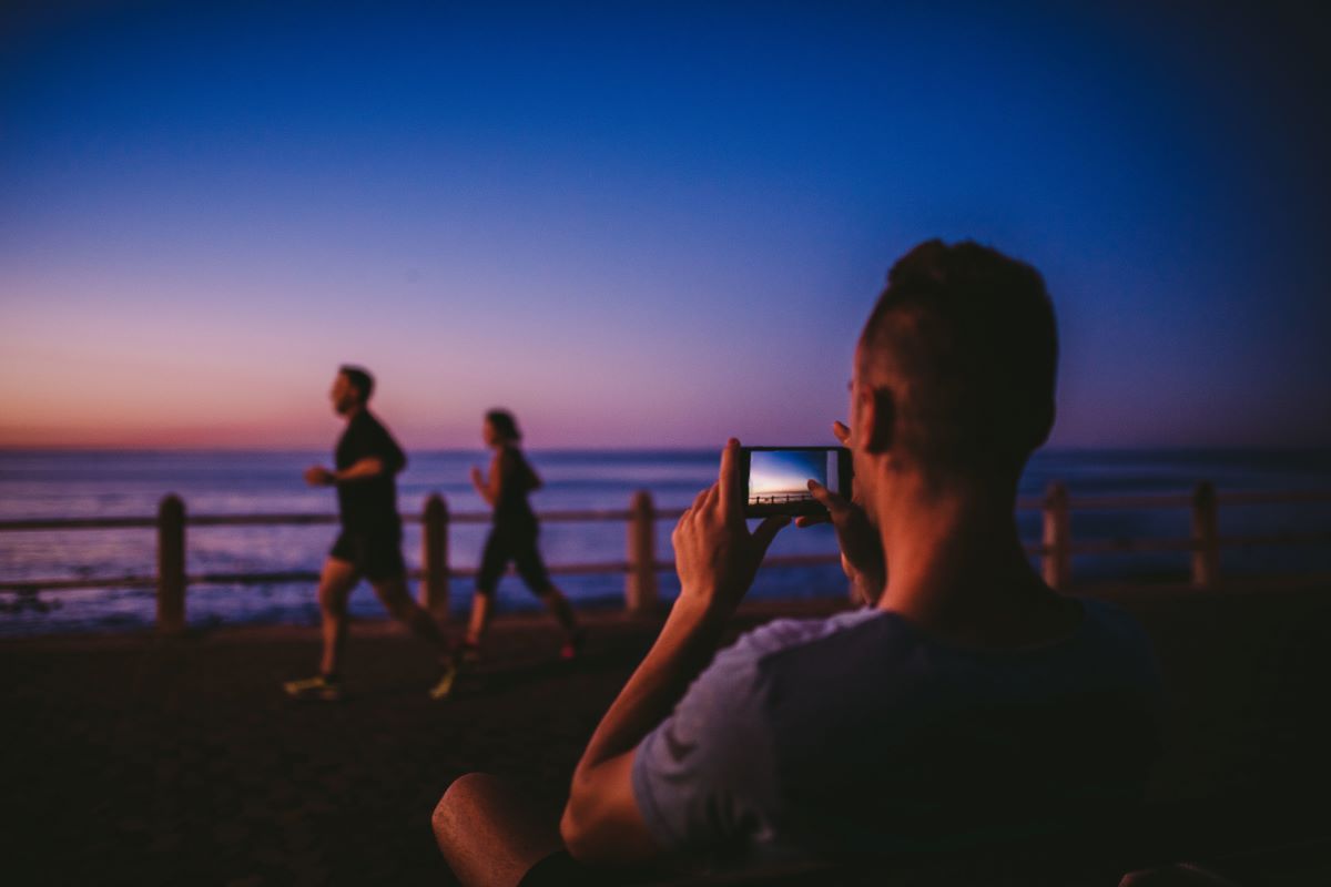 a guy taking picture of two individuals