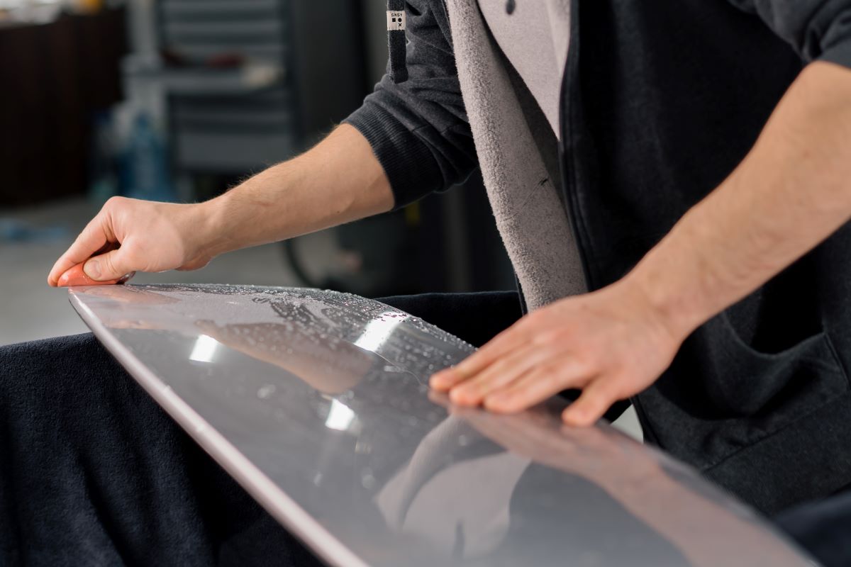 a mechanic preparing a car spolier for gluing