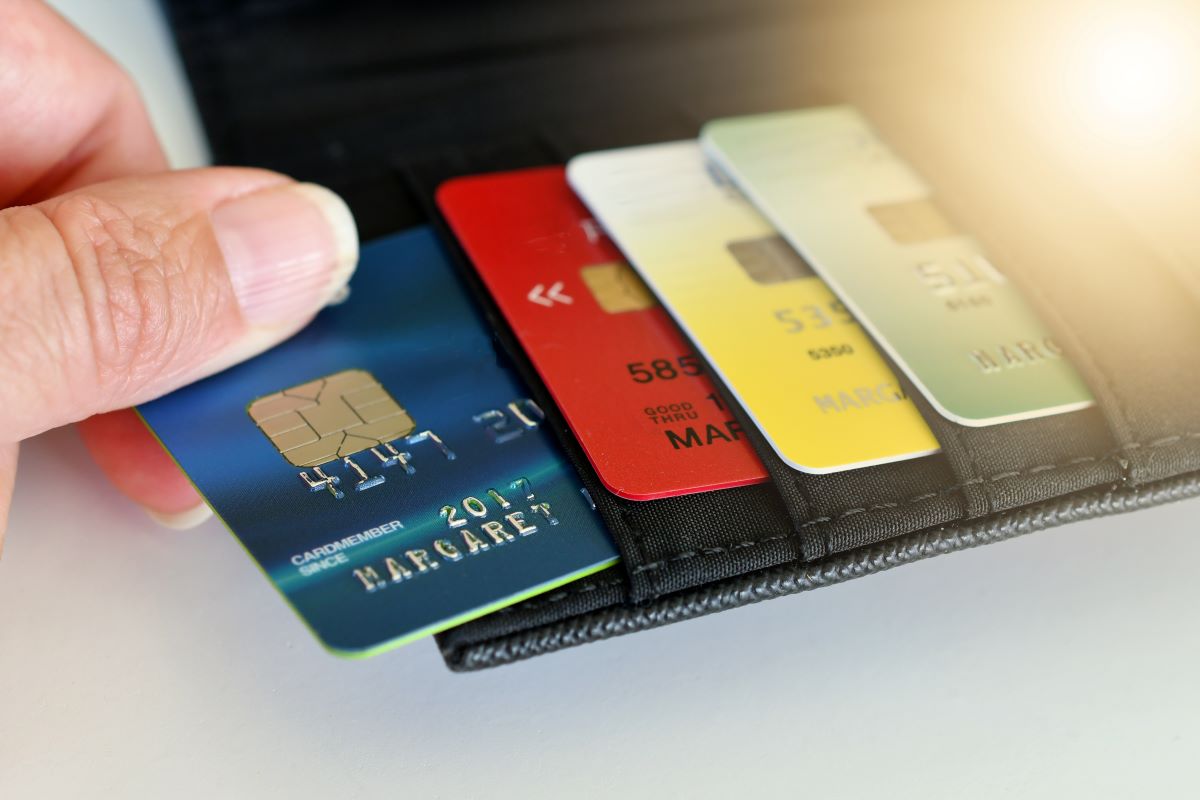 a person pulling out a credit card from the wallet for shopping