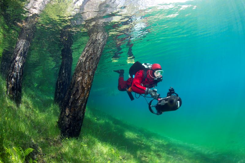 person swimming by wearing scuba dive suite