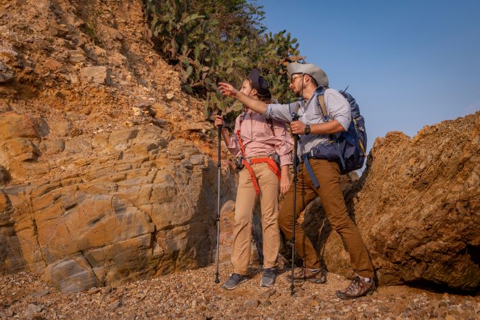 one male hikers pointing to other side with female hiker