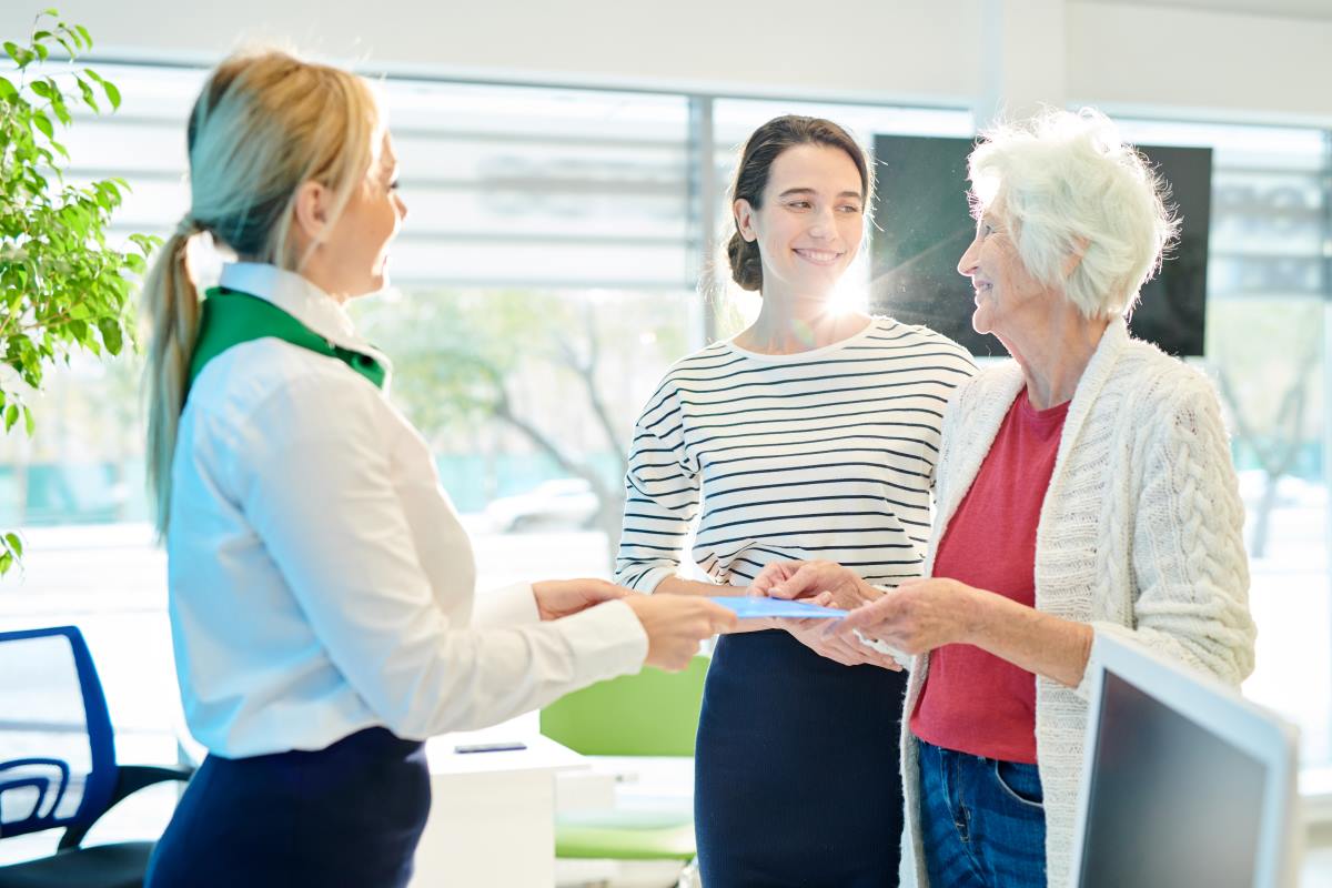 bank manager giving documents to the old woman