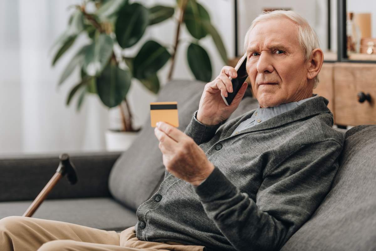 an old man on call with credit card in hand