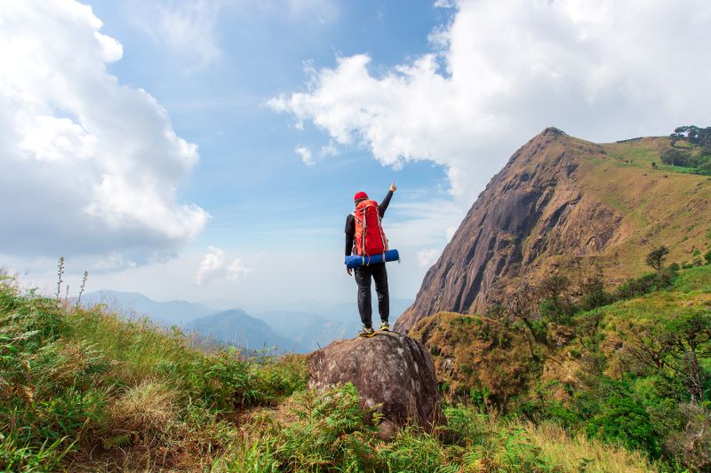 a guy raising hands up from top of the hills