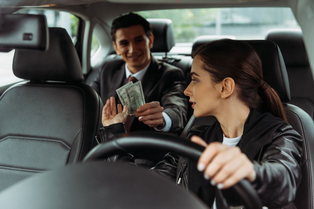 Taxi driver taking money from passenger