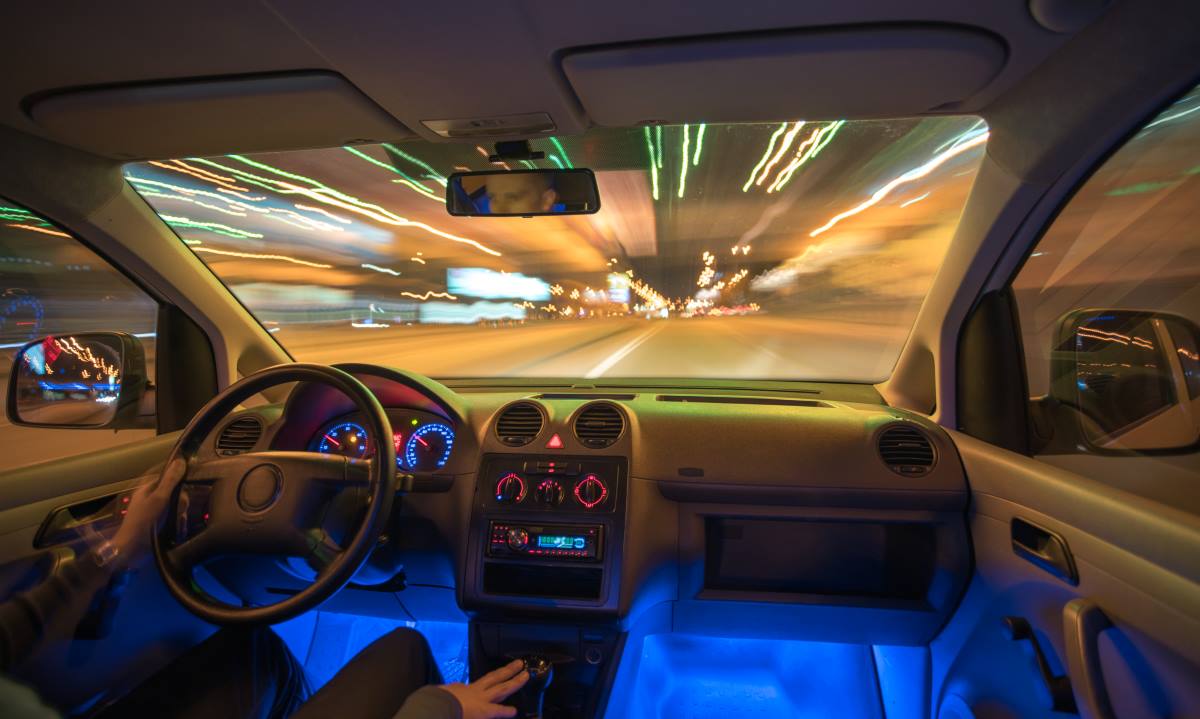 man driving a car with ambients lighting in night