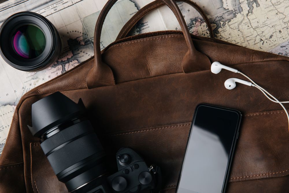 brown leather bag with mobile phone and camera