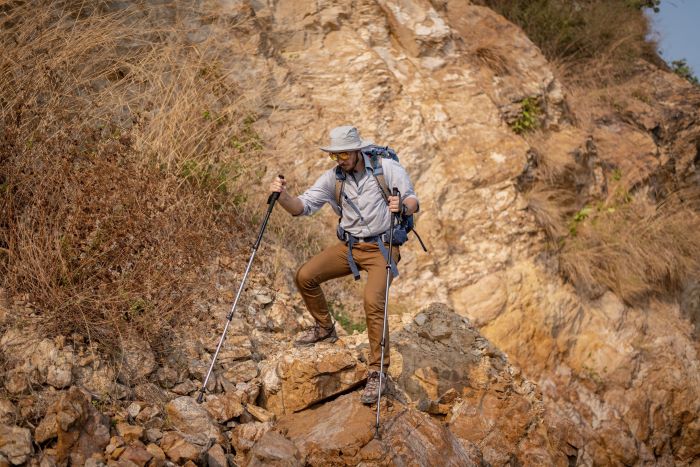 guy hiking while holding stick