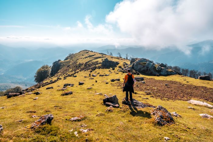 a man at the top of the hill seeing the view