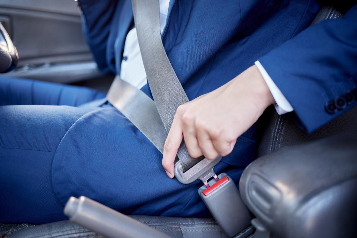 a business man wearing his seat belt in a car