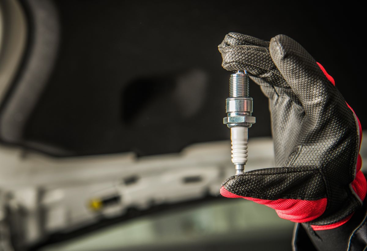 a mechanic holding glow plug in a hand