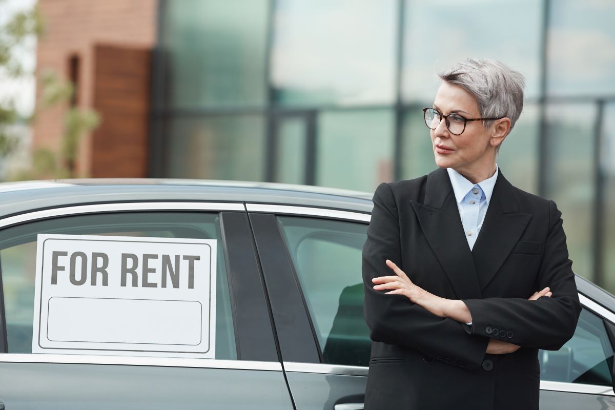 a women with rent board on car