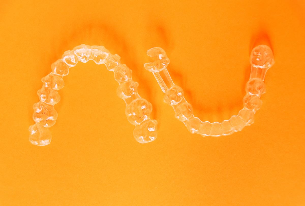 top view of clear isolated aligners with an orange background