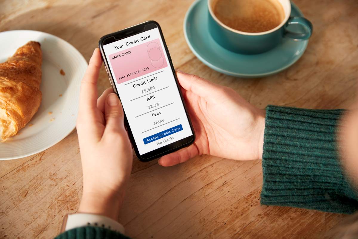 A woman applying for a credit card in a cafe through online