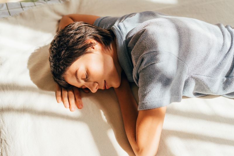 woman-lies-relaxed-on-a-bed-in-the-light