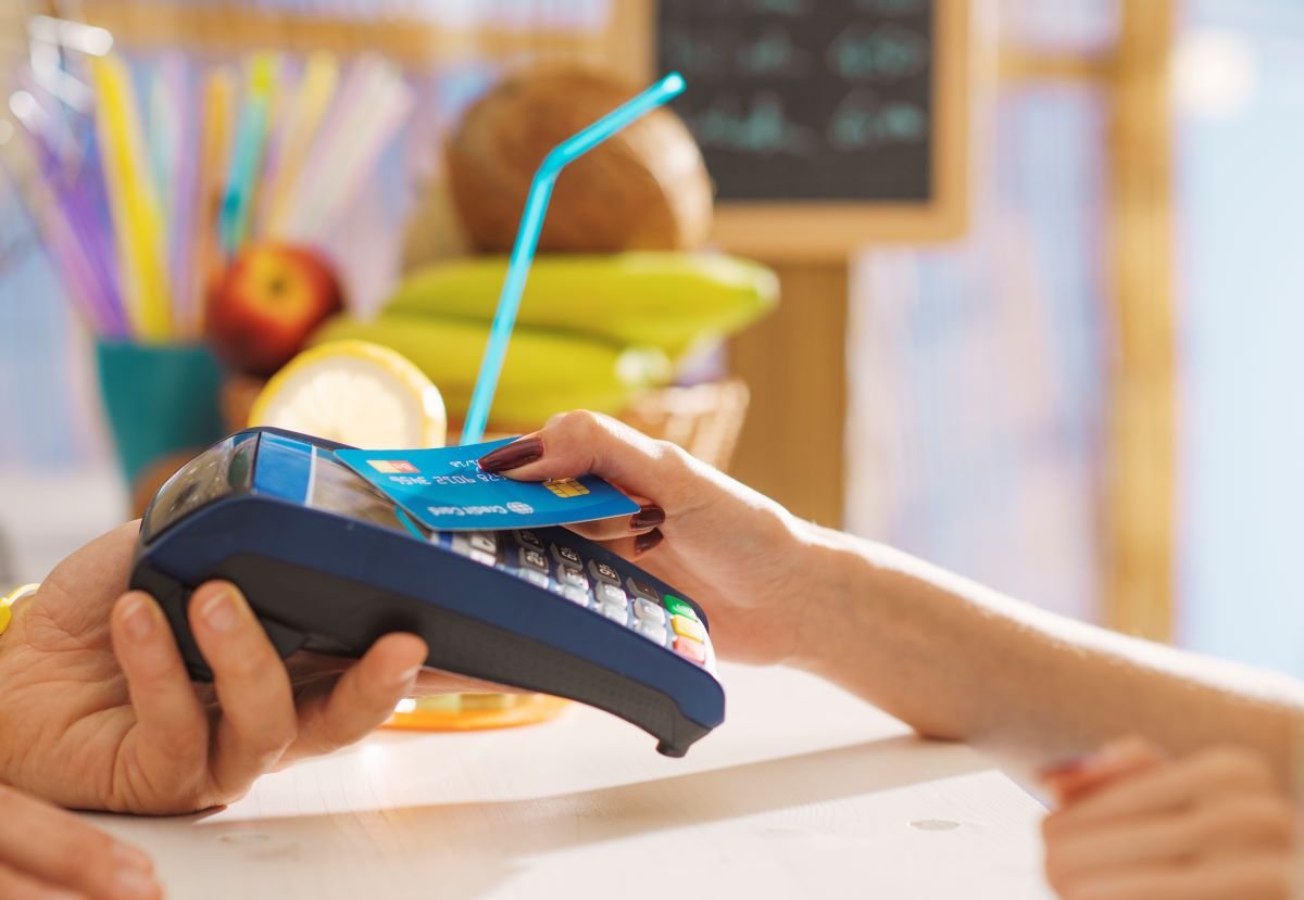 woman using a contactless credit card for making a payment