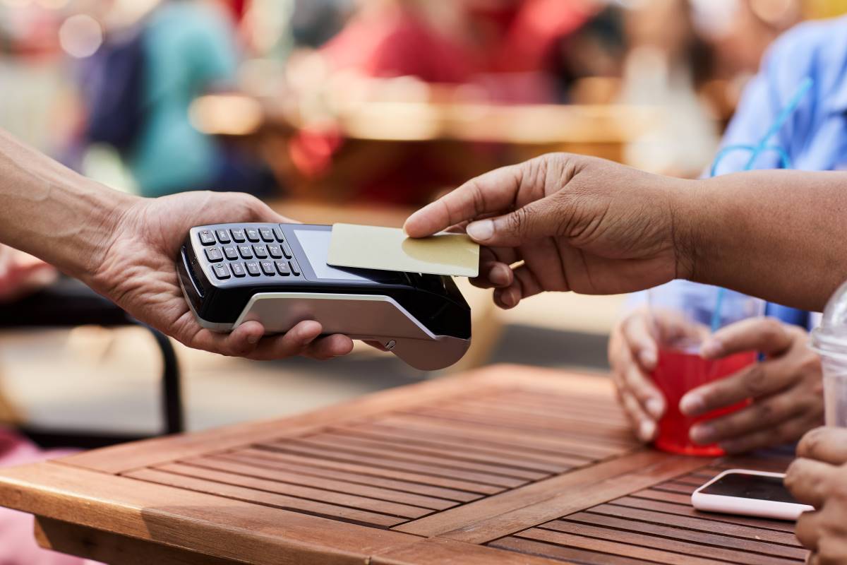 senior woman using lifestyle credit card on outdoor cafe