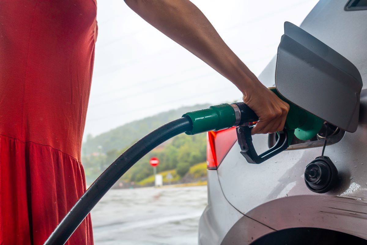 a woman from the fuel station refueling the gasoline for the car