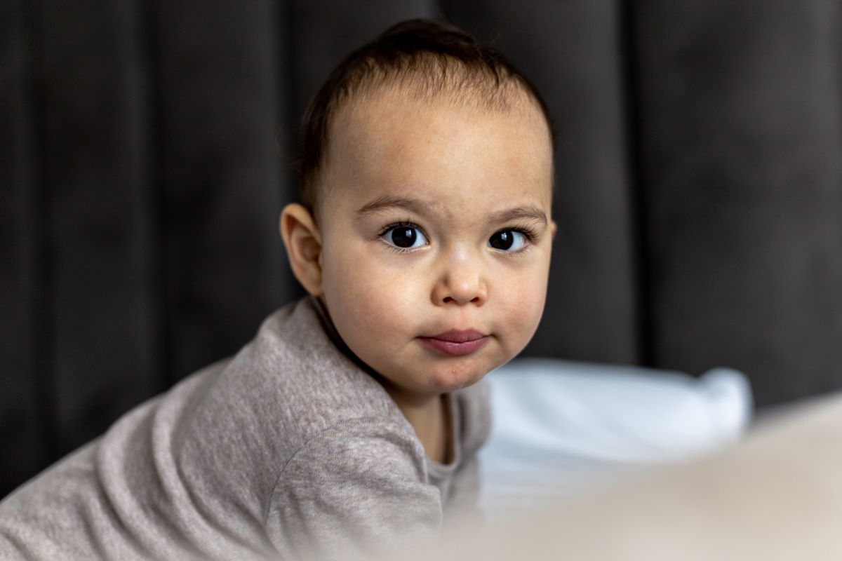 baby boy sitting on bed