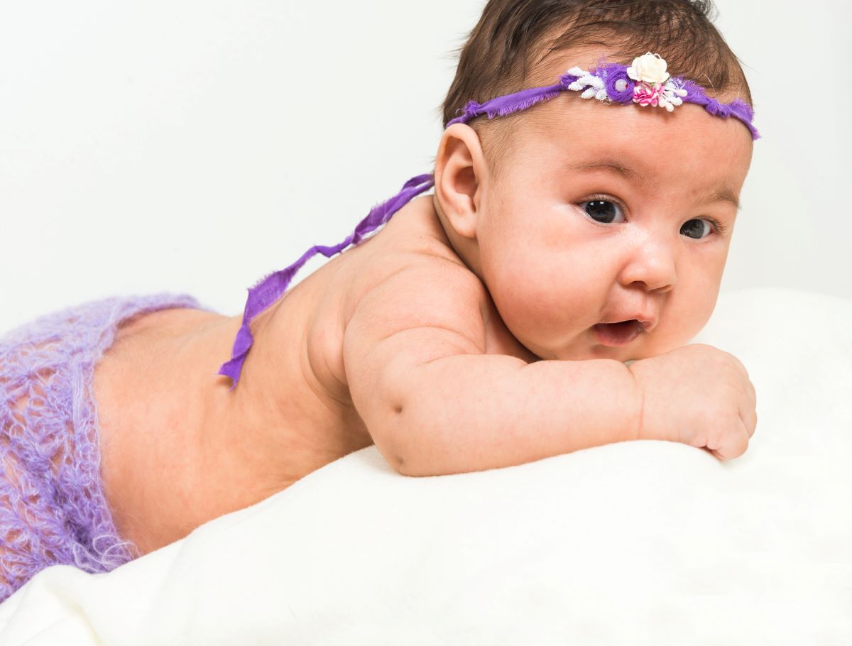 baby girl lying on bed