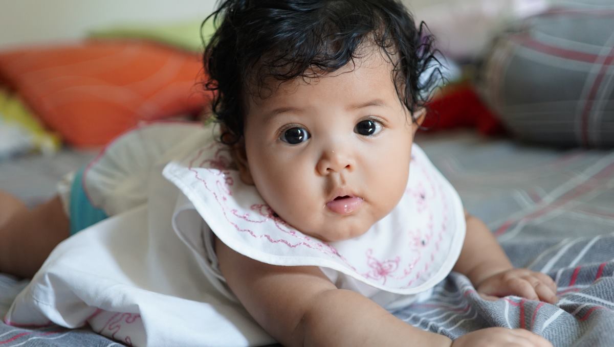 baby girl lying on bed