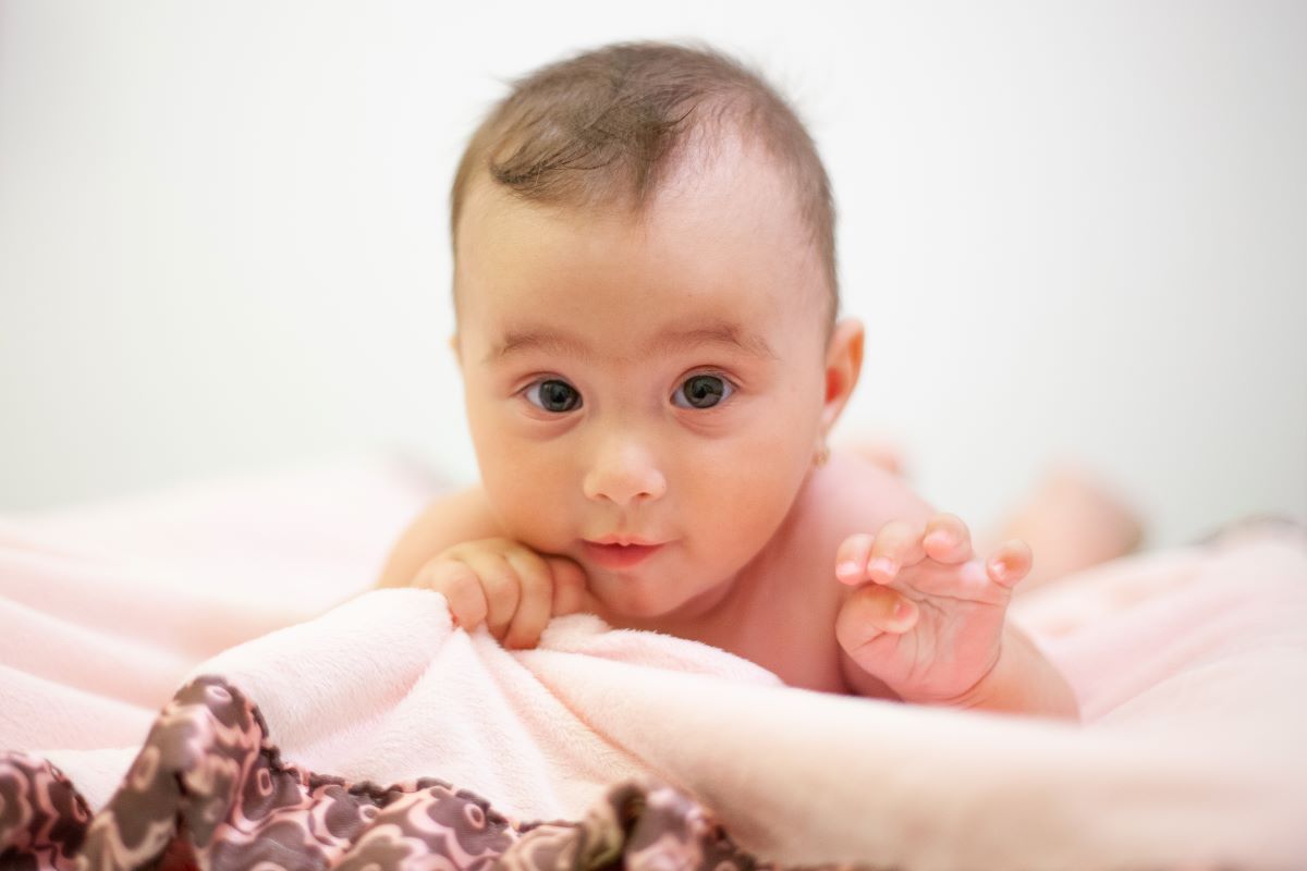 baby girl sitting on her tummy