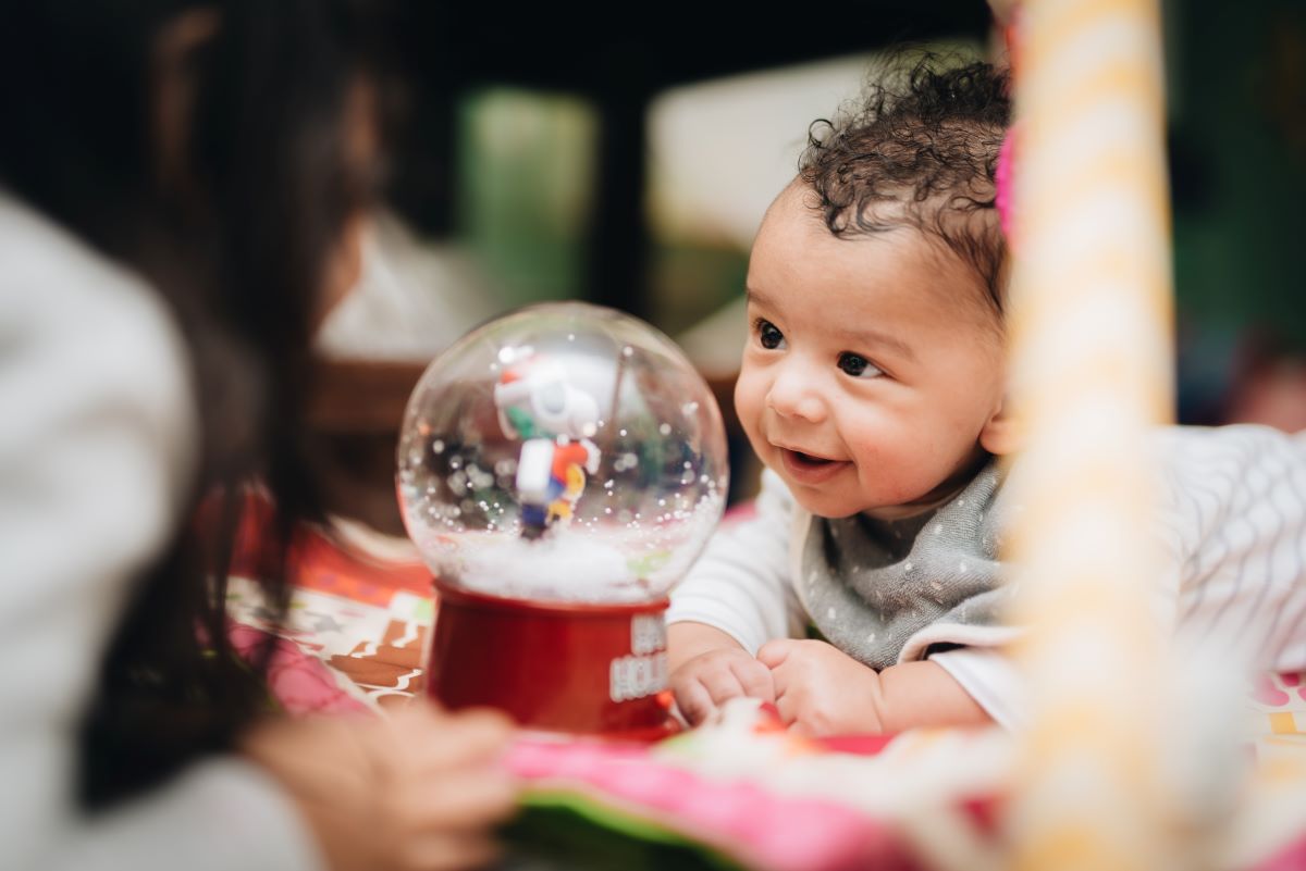 baby playing and looking at snow globe